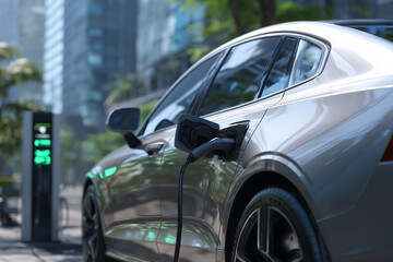 Electric car charging at modern EV station in urban green environment with futuristic lighting