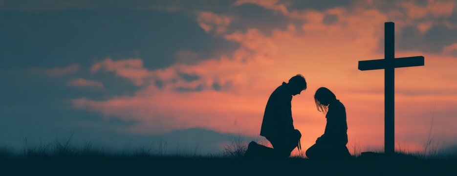 Man and woman praying together at sunset by cross  