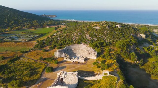 Gelemis, Turkey. Patara Ancient Theatre archaeological site on Kursunlu Hill, historical tourism in Turkey, summer morning. Aerial View, MasterShots, Circle (Far)