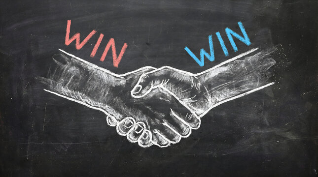 Handshake symbolizing win-win business partnership on chalkboard