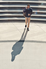 Business, man and smile with phone call outdoor for discussion, real estate and negotiation. Above, realtor and coffee with mobile for networking, contact client and auction schedule of buyer inquiry