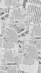 Obraz premium Overlapping torn pieces of black and white newspaper create abstract background texture