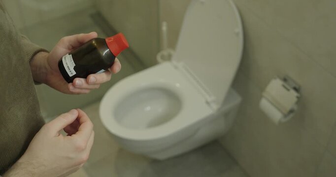 Realistic scene of a man holding laxative medicine in a home bathroom near a toilet, symbolizing digestive problems, constipation relief, and healthcare treatment.