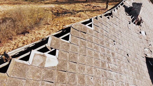 Cinematic aerial close up of decaying Soviet farm roof with broken shingles