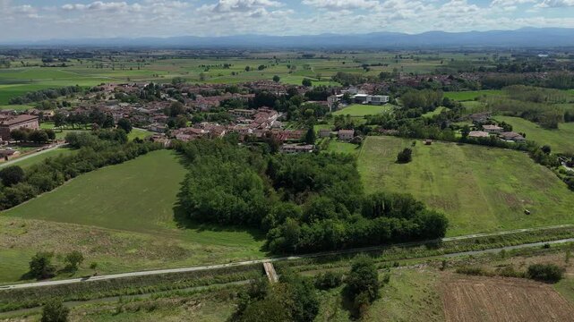 Chignolo&rsquo;s compact rural settlement and the Castello Procaccini complex set among cultivated Po Valley plains, hedgerows, and irrigation corridors in the Province of Pavia, Lombardy, Italy
