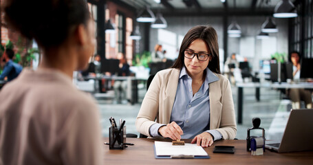 Young Woman Notarizing Trademark Document At Law Office