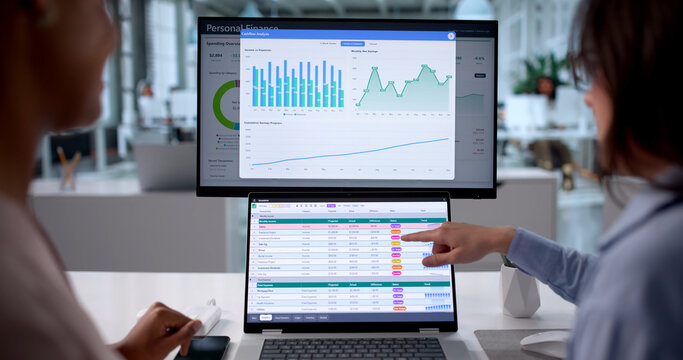 Women Analyze Financial Data Using Spreadsheets And Charts