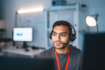 Portrait young adult indian man wearing headset remote work online technical support business...