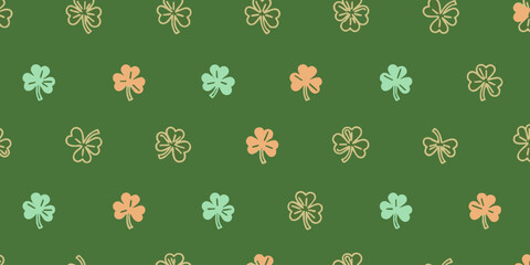 Repeating pattern of colorful shamrocks on a green background viewed from directly above