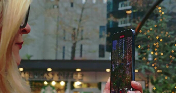 Woman Records Holiday Decorations in Urban Setting