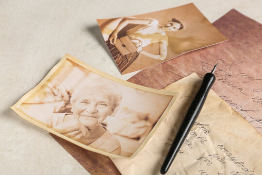 Old photos of relatives with letters and pen on light background, closeup. Concept of family tree