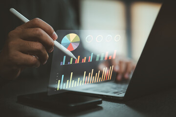 Person analyzing colorful digital graphs and charts on a laptop with stylus pen