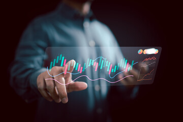 Businessman interacting with futuristic digital stock market graph and financial charts on transparent screen