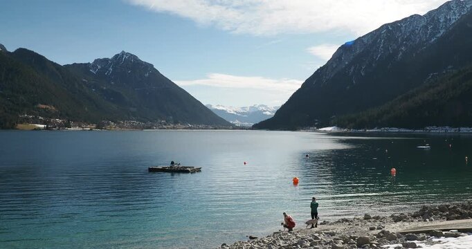 Lake Achen (Achensee) on slopes of Karwendel massif and Rofan in Austrian Tyrol. View from the beach of Pertisau towards Maurach city between Hochiss peaks (left) and B&auml;renkopf (right)
