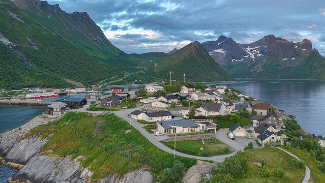 12 july 2025, Hus&oslash;y, Norway. Aerial, drone view of little village Husoy and island in &Oslash;yfjorden fjord during sunset. Beautiful nature, mountains surrounding fjord, wonderful golden reflection in the w
