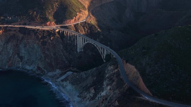 Evening drone survey of rocky coastlines. Nighttime drone captures rugged terrain and highway scene. Unmanned aerial vehicle documents rugged seaside landscape during sunset hours
