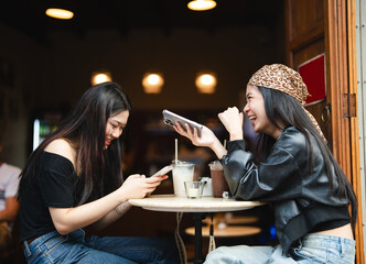Obraz premium Two young asian woman gen z using smartphone share lifestyle happiness travel moment on social media in Bangkok