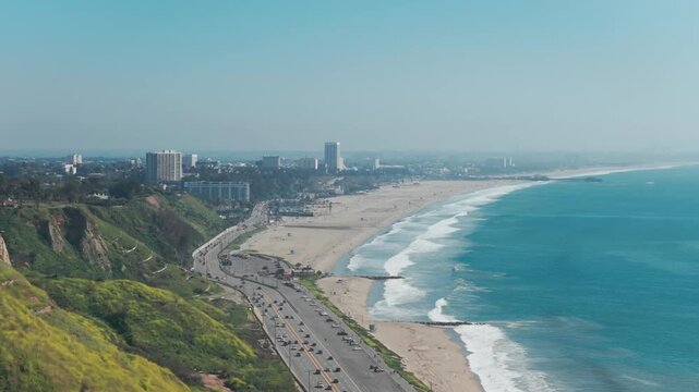 Telephoto dolly aerial shot of Santa Monica State Beach on a spring day in Southern California. 4K