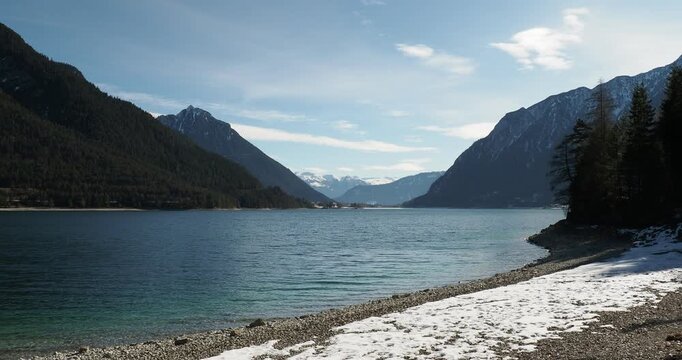 West shore of Achensee in Austrian Tyrol from Pertisau to Gaisalm with beautiful view of the Karwendel and Rofan mountain ranges and snow-capped peaks of Zillertal valley on southern horizon
