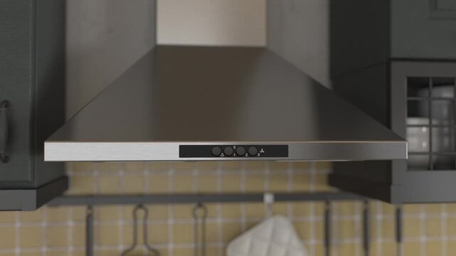 Close-up of a modern stainless steel kitchen extractor hood with push buttons, elegant kitchen interior design with dark cabinets.