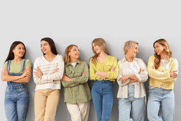 Fototapeta premium Portrait of beautiful women with crossed arms on grey background