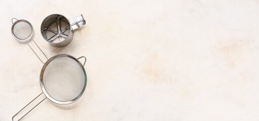 Fototapeta premium Set of metal sieves on light background with space for text