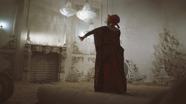 Female shaman or african priestess dancing alone in unique studio, ritual dance. Black lady in traditional ethnic gown and turban asking for rain, dance on sand in desert, art performance, dance show