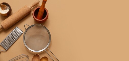 Set of kitchen utensils on brown background with space for text