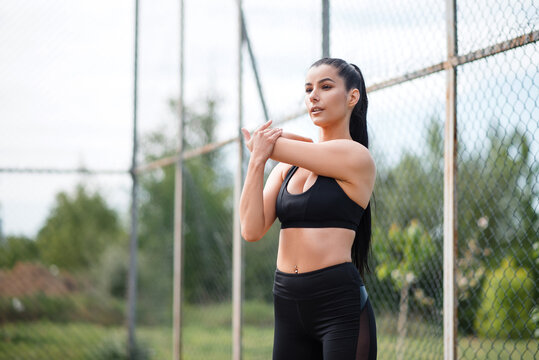 Fitness brunette woman in black leggings training outdoor