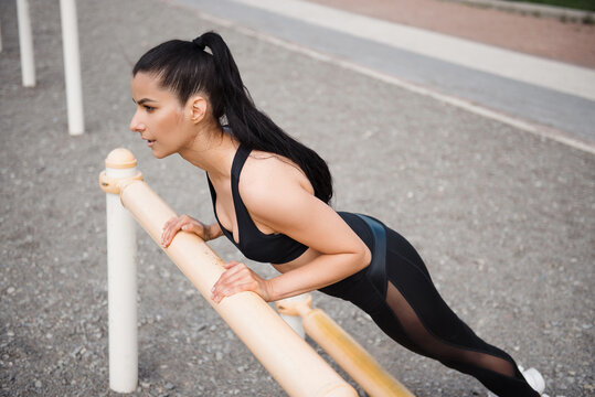 Woman Doing Push-ups on Parallel Bars