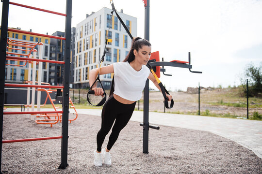 Fitness brunette woman in black leggings training outdoor