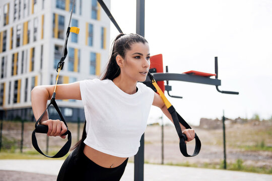 Fitness brunette woman in black leggings training outdoor