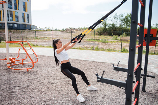 Fitness brunette woman in black leggings training outdoor