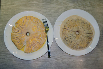Breaded parasol mushroom cap with breadcrumbs on a plate with beaten egg