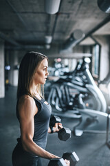 Fototapeta premium Workout, dumbbell and training with woman in gym for fitness, muscle development and bicep curl. Bodybuilder weights, strong and sports athlete with person and exercise equipment for weightlifting