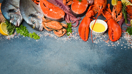 Fresh seafood. Wide food banner. Fish, octopus, lobster and other seafood on a gray stone table.