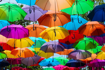 Obraz premium Colorful Umbrellas Hanging Outdoors.Beautiful vibrant umbrellas canopy decoration in a sunny outdoor park.