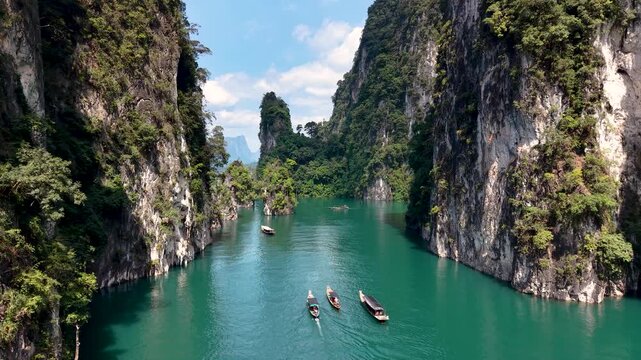 Journey through the stunning landscapes of Khao Sok, Thailand, where vibrant emerald waters meet towering cliffs, inviting adventure and tranquility amidst natural beauty.