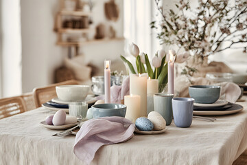 Table set for a spring meal with candles and flowers during late morning in a bright room