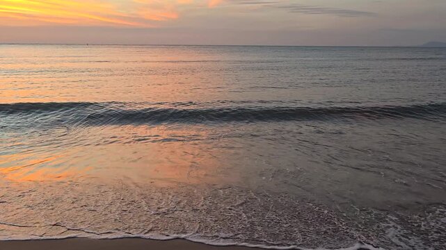 Watch as the sun rises over Baan Kruud Beach, casting a golden glow on the calm waters while gentle waves lap at the shore. Experience the serene beauty of a Thailand morning.