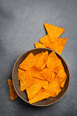 Mexican snacks. Ceramic bowl with nachos chips. Top view, on stone background.