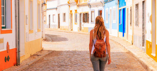 Fototapeta premium Woman tourist walking in colored street in Portugal