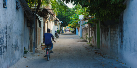 Rasdhoo Island. Man riding a bicycle in a local island. Maldives 