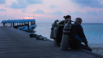 Maldives. Divers in a pier waiting to dive during sunset