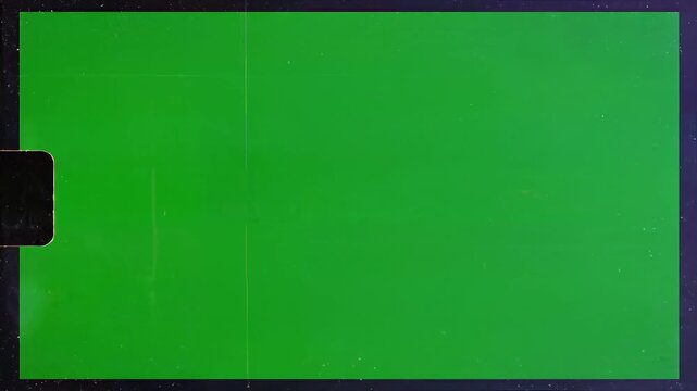 A vibrant green screen dominates the frame bisected by a thin red line and featuring film grain effects