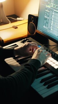 Music production. Man finger drumming on the drum pads of a MIDI keyboard. Home studio