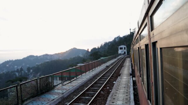 passenger train window view along mountain railway at sunset video is taken at shimla himachal pradesh india.