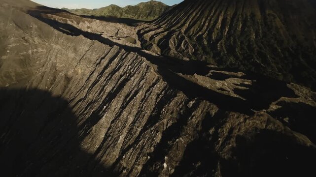 Dynamic FPV drone footage diving across the Mount Bromo volcano crater in East Java Indonesia showing dramatic volcanic landscape and rugged terrain.