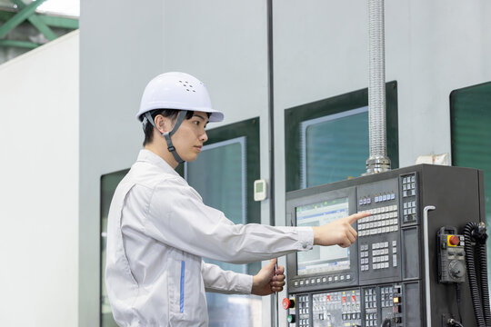 工場の操作盤の前で働く男性作業員