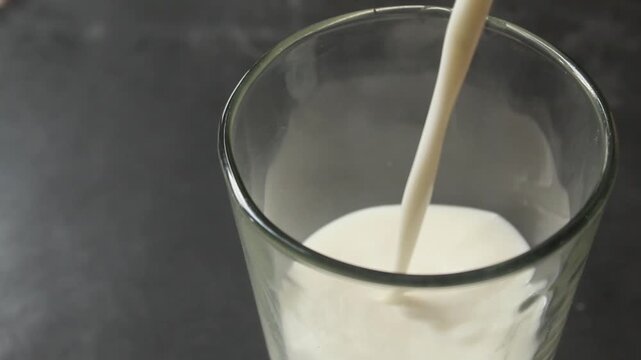 close up of pouring milk into a glass